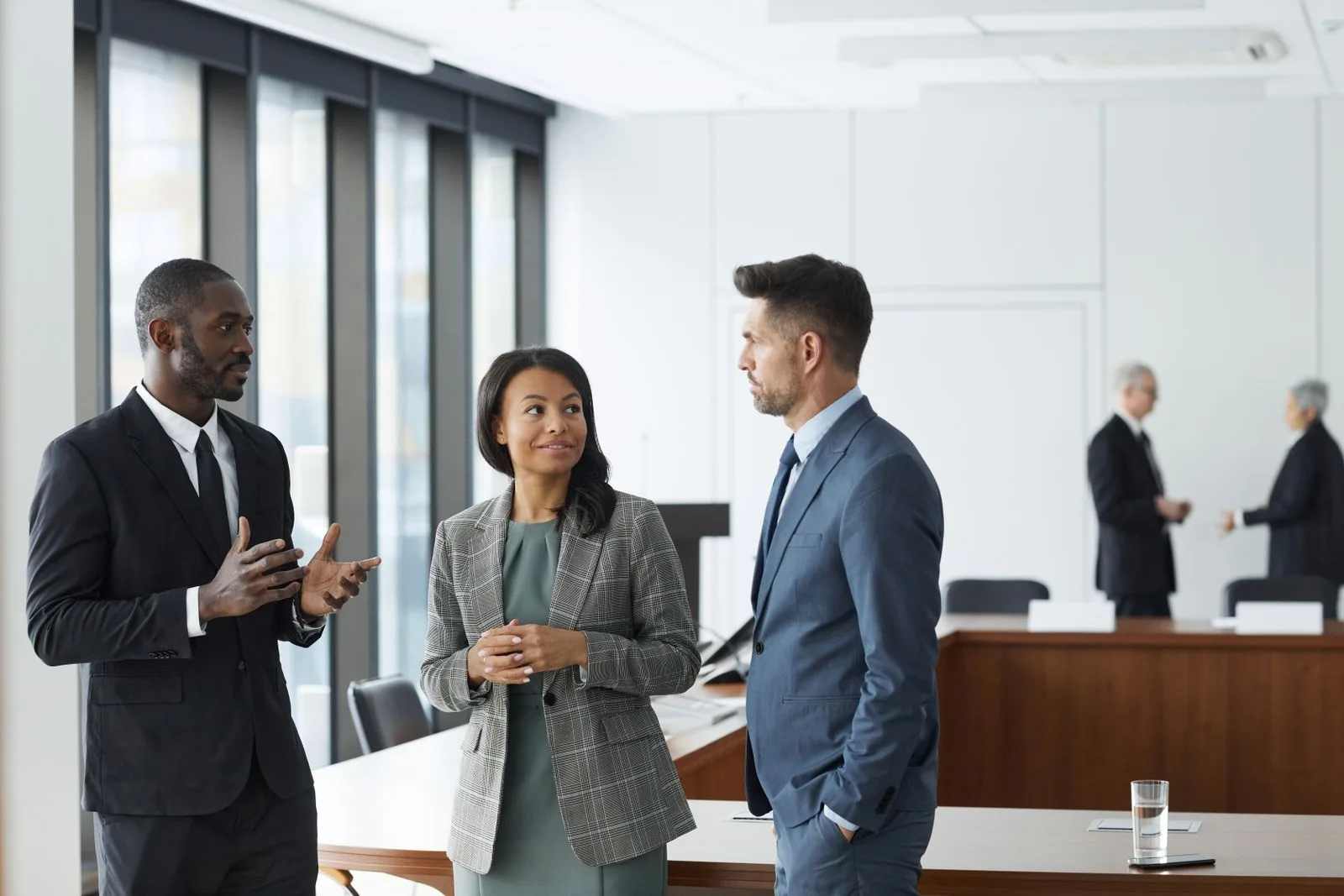 Corporate finance adviser in a suit leading a discussion with colleagues in a boardroom