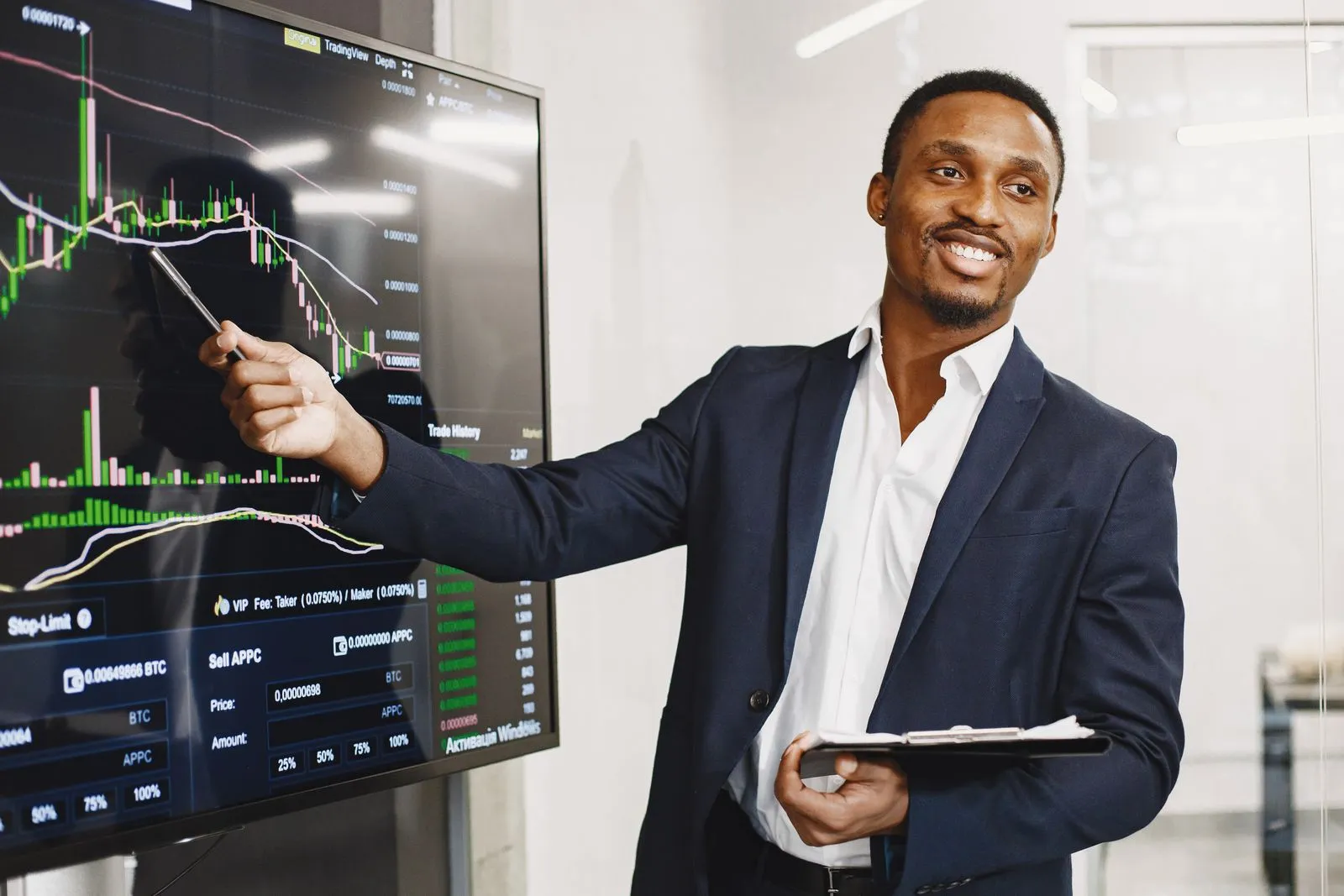 Equity broker in a suit presenting stock market charts on a trading screen